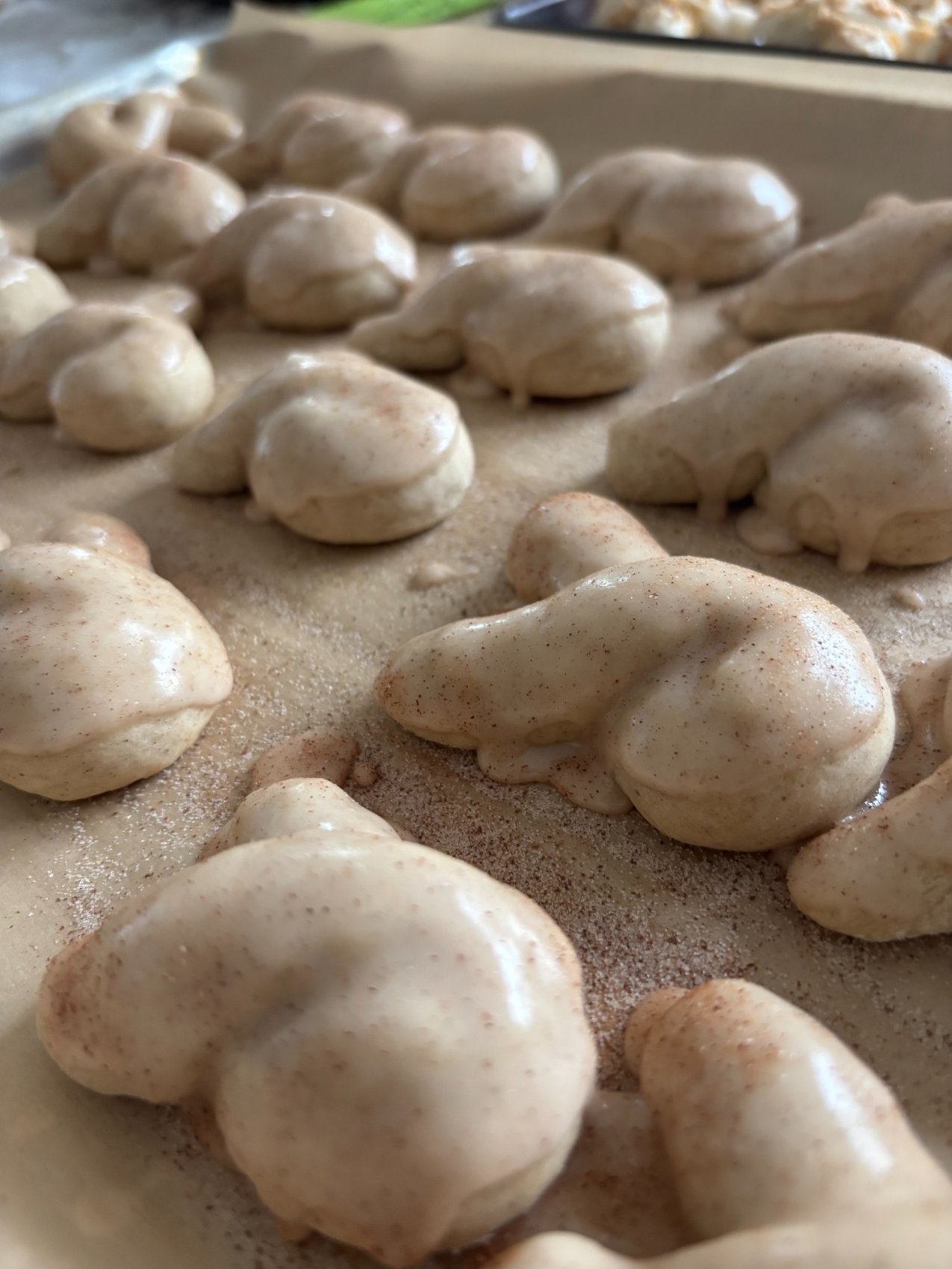 Freshly glazed cookies resting on parchment